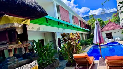 an umbrella and chairs next to a swimming pool at Ellenbrook Rooms 18 by Mulia Cottage in Seminyak