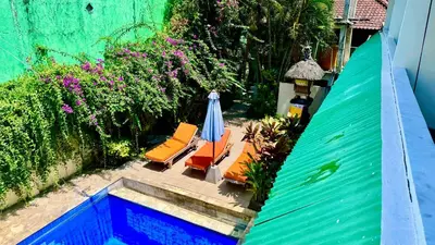 an overhead view of a patio with chairs and an umbrella at Ellenbrook Rooms 17 by Mulia Cottage in Seminyak