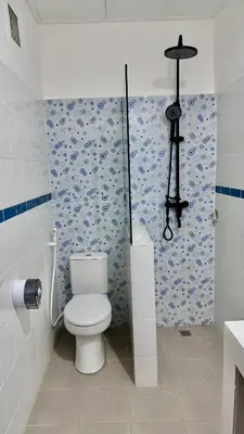 a bathroom with a toilet and blue and white wallpaper at Ellenbrook Rooms 17 by Mulia Cottage in Seminyak