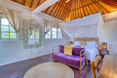a bedroom with a bed and a purple chair at Villa Sabi 3BR in the Heart of Seminyak by Santi Management in Seminyak