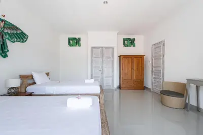 a white room with two beds and a table at Villa Chunga-changa Double six in Seminyak