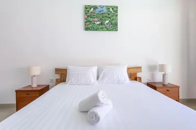 a bedroom with a white bed with towels on it at Villa Chunga-changa Double six in Seminyak