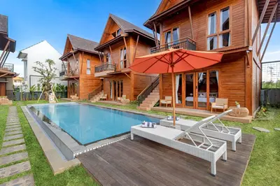 a house with a swimming pool and an umbrella at Anartha Resort Jimbaran By Kubu GWK in Jimbaran