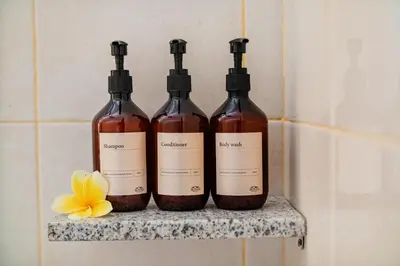 three bottles of wine sitting on a shelf in a bathroom at Anartha Resort Jimbaran By Kubu GWK in Jimbaran