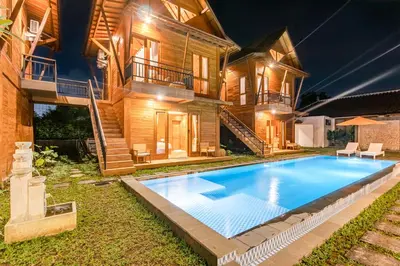 a house with a swimming pool in front of it at Anartha Resort Jimbaran By Kubu GWK in Jimbaran