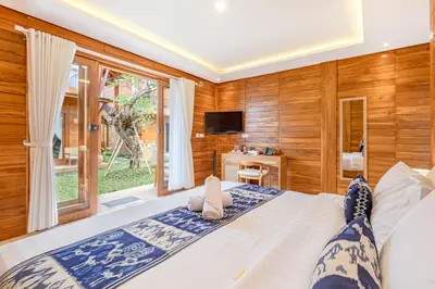 a bedroom with a large bed with a window at Anartha Resort Jimbaran By Kubu GWK in Jimbaran