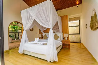 a bedroom with a white bed with a canopy at Mya Harmony Villas Seminyak in Seminyak