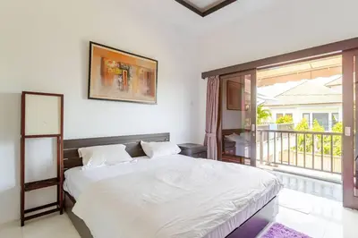 a bedroom with a large bed and a balcony at Villa with private pool in Nusa Dua in Nusa Dua