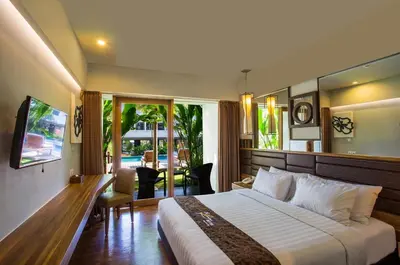 a hotel room with a bed and a sliding glass door at The Lerina Hotel Nusa Dua in Nusa Dua