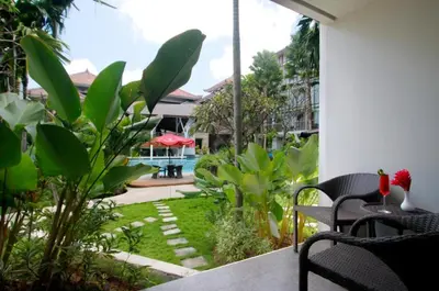 a patio with a table and chairs and a garden at The Lerina Hotel Nusa Dua in Nusa Dua
