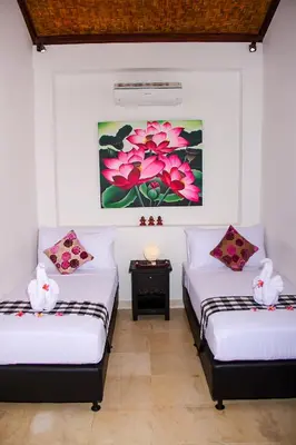two beds in a room with a painting on the wall at Villa Gardenia - 6 Bedrooms with Pool in Seminyak in Seminyak