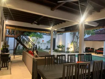 a patio with a table and chairs and a couch at Villa Gardenia - 6 Bedrooms with Pool in Seminyak in Seminyak