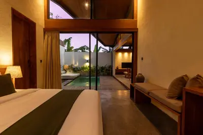 a bedroom with a bed and a view of a pool at Rarama Teba Villa in Umalas