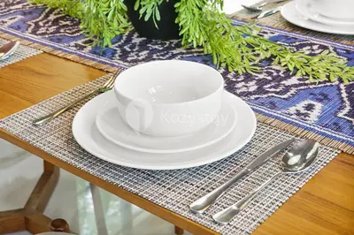 a table with a white cup and plates and silverware at Kanani Villa by Kozystay - Umalas in Seminyak
