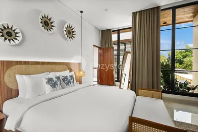 a bedroom with a large bed and a window at Kanani Villa by Kozystay - Umalas in Seminyak