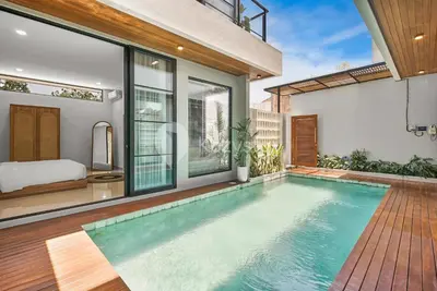 an indoor swimming pool in the backyard of a house at Kanani Villa by Kozystay - Umalas in Seminyak
