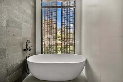 a white bath tub in a bathroom with a window at Kanani Villa by Kozystay - Umalas in Seminyak