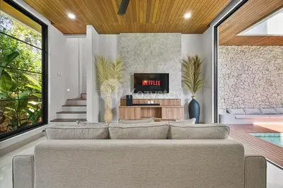 a living room with a couch and a tv at Kanani Villa by Kozystay - Umalas in Seminyak