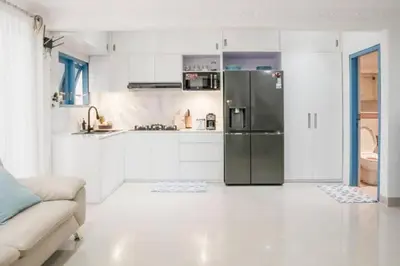 a kitchen with a stainless steel refrigerator and white cabinets at Altea Villa Legian - 2BR Private Pool, Prime Location & Walk to Beach in Legian