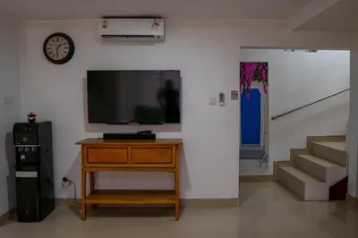 a living room with a tv and a dresser and stairs at Altea Villa Legian - 2BR Private Pool, Prime Location & Walk to Beach in Legian