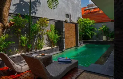 a swimming pool in a backyard with chairs and a table at Altea Villa Legian - 2BR Private Pool, Prime Location & Walk to Beach in Legian