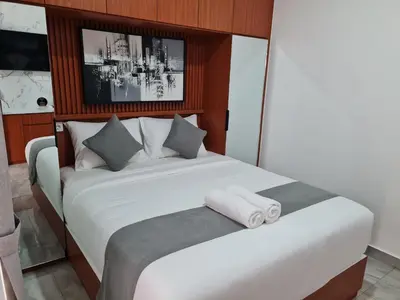 a bedroom with a white bed with two towels on it at Shin In Bali in Kuta