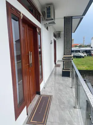 a building with a wooden door and a balcony at Shin In Bali in Kuta