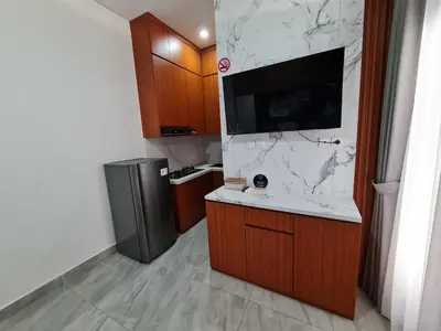 a kitchen with a counter with a tv and a refrigerator at Shin In Bali in Kuta
