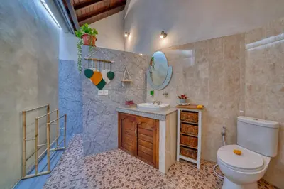 a bathroom with a toilet and a sink at Peaceful 2bd Seminyak villa with Private Pool and Garden in Seminyak