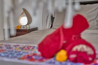 a bed with a red blanket and a mirror at Peaceful 2bd Seminyak villa with Private Pool and Garden in Seminyak