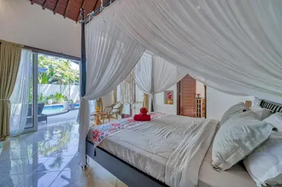a bedroom with a large bed with a canopy at Peaceful 2bd Seminyak villa with Private Pool and Garden in Seminyak