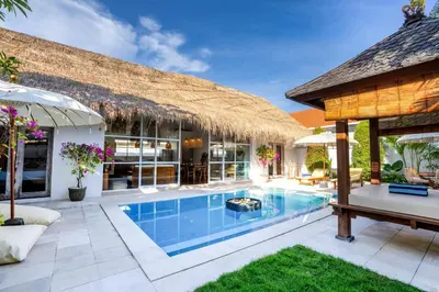 an outdoor swimming pool with a pavilion and a house at Villa Bardo by Pertama Management in Seminyak