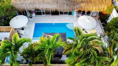 an aerial view of a resort with a swimming pool and palm trees at Villa Bardo by Pertama Management in Seminyak