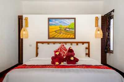two teddy bears sitting on top of a bed at Villa Bardo by Pertama Management in Seminyak