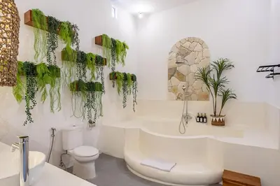 a bathroom with a tub and a toilet and a sink at Villa Dalon by Optimum Bali Villas in Seminyak