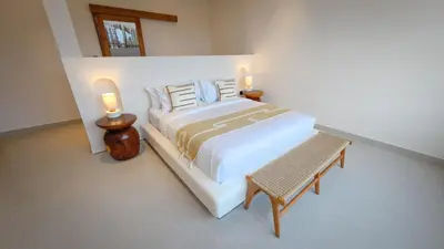 a bedroom with a bed with two candles on it at Miko Villa Seminyak in Seminyak