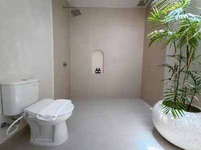 a bathroom with a toilet and a potted plant at Miko Villa Seminyak in Seminyak