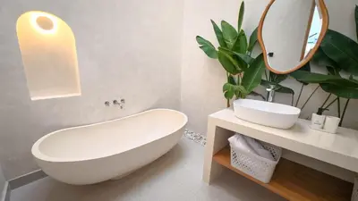 a bathroom with a white tub and a mirror at Miko Villa Seminyak in Seminyak