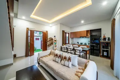 a living room with a couch and a kitchen at Promo!! New Rosa Villa Muding, Luxury and cozy 3Bedrooms Villa in Heart of Kerobokan with Special Office Room in Kerobokan
