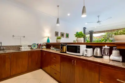 a kitchen with wooden cabinets and a counter with microwaves at Bens Tunjung Villa Two-Bedroom with Private Pool Kuta in Seminyak