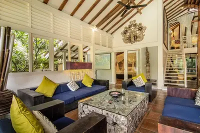 a living room with a blue couch and a table at Villa Kija in Seminyak