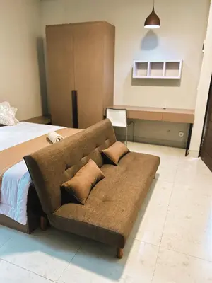 a couch in a bedroom with a bed at Nawasena Suites in Sanur