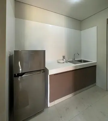a kitchen with a stainless steel refrigerator and a sink at Nawasena Suites in Sanur