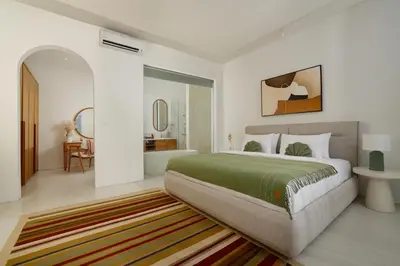 a bedroom with a large bed and a bathroom at Villa Kalem Canggu by Nakula in Canggu
