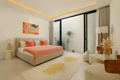 a bedroom with a bed and a living room at Villa Kalem Canggu by Nakula in Canggu