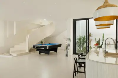 a living room with a pool table and stairs at Villa Kalem Canggu by Nakula in Canggu