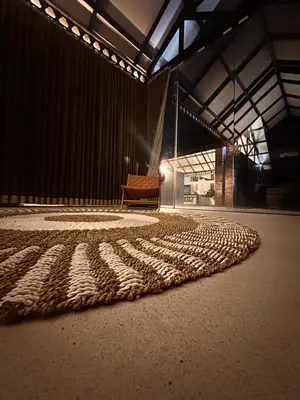 a rug on the floor in a room with a chair at The Edge by Anima in Kerobokan