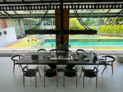 a dining room table with chairs and a large window at The Edge by Anima in Kerobokan
