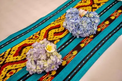 two flowers sitting on top of a colorful rug at Bens Mertanadi Villa Two-Bedroom with Private Pool Kuta in Seminyak