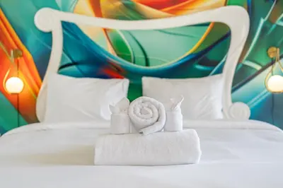 a white bed with towels and two dolls on it at Viewbali 2- Modern Villa with Stunning Rooftop Views in Kerobokan